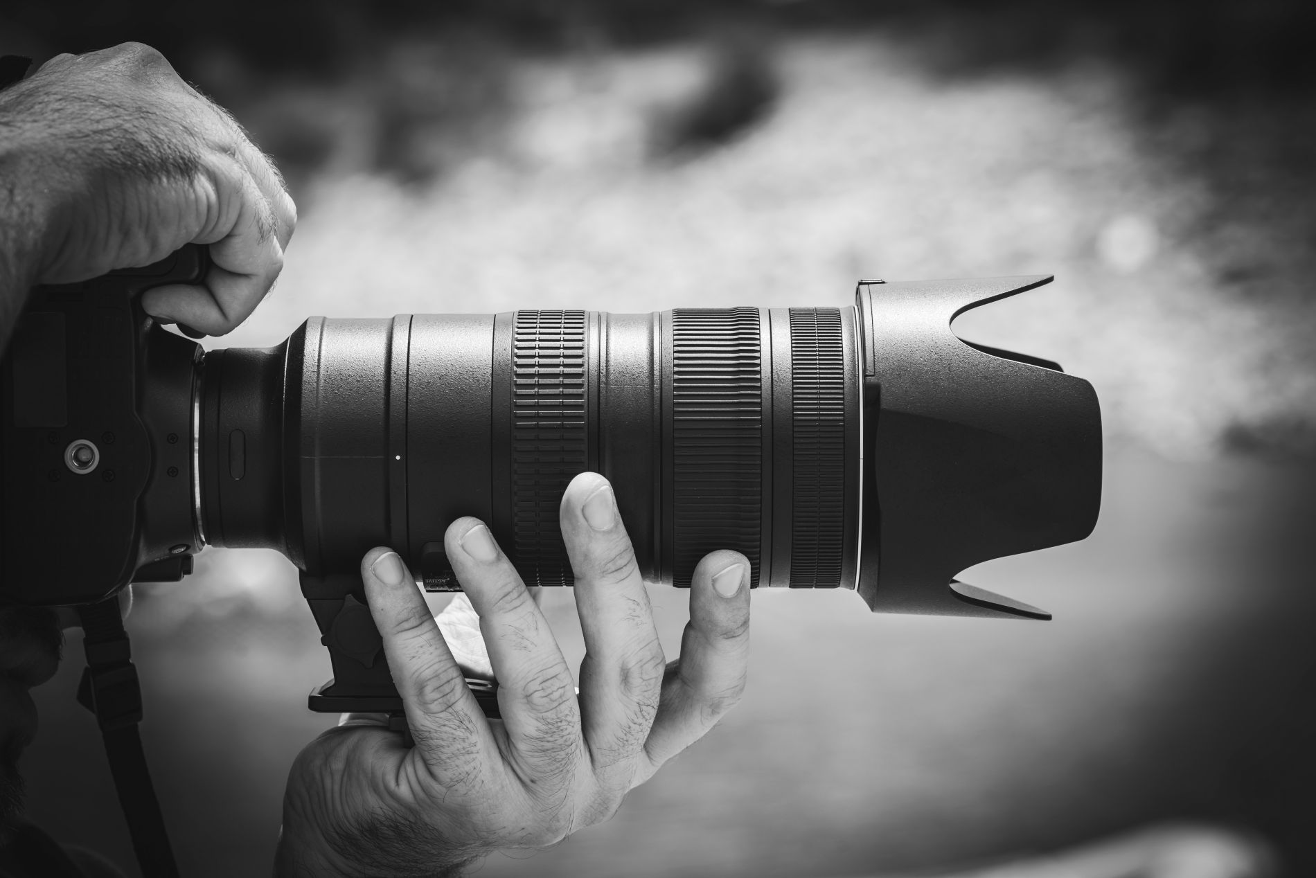 Hands holding a digital SLR camera with zoom digital lens