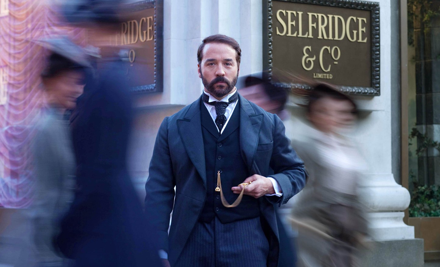 A man standing in front of Selfridge and Co sign